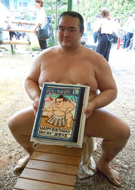 Sumo. Il lottatore di sumo Kisenosato mostra la torta di compleanno durante il Nagoya Grand Sumo Tournament. Giappone. (Afp)